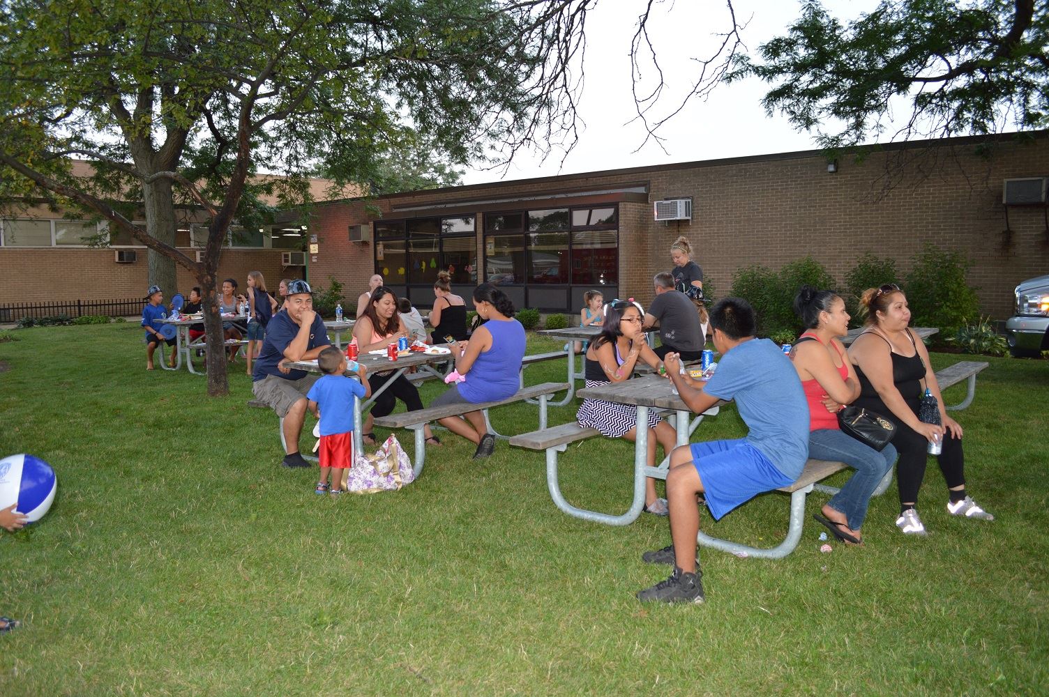 Community members enjoy food at picnic tables during a National Night Out event at the Iowa Community Center, Aug. 2.